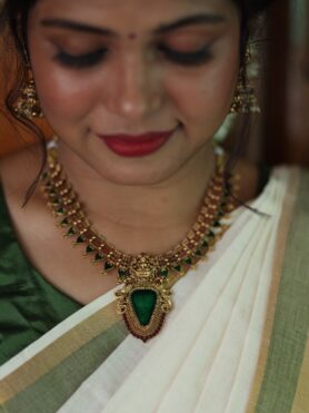 GOLDEN ALIKE NECKLACE SET WITH GREEN LEAF SHAPED STONE MOTIFS